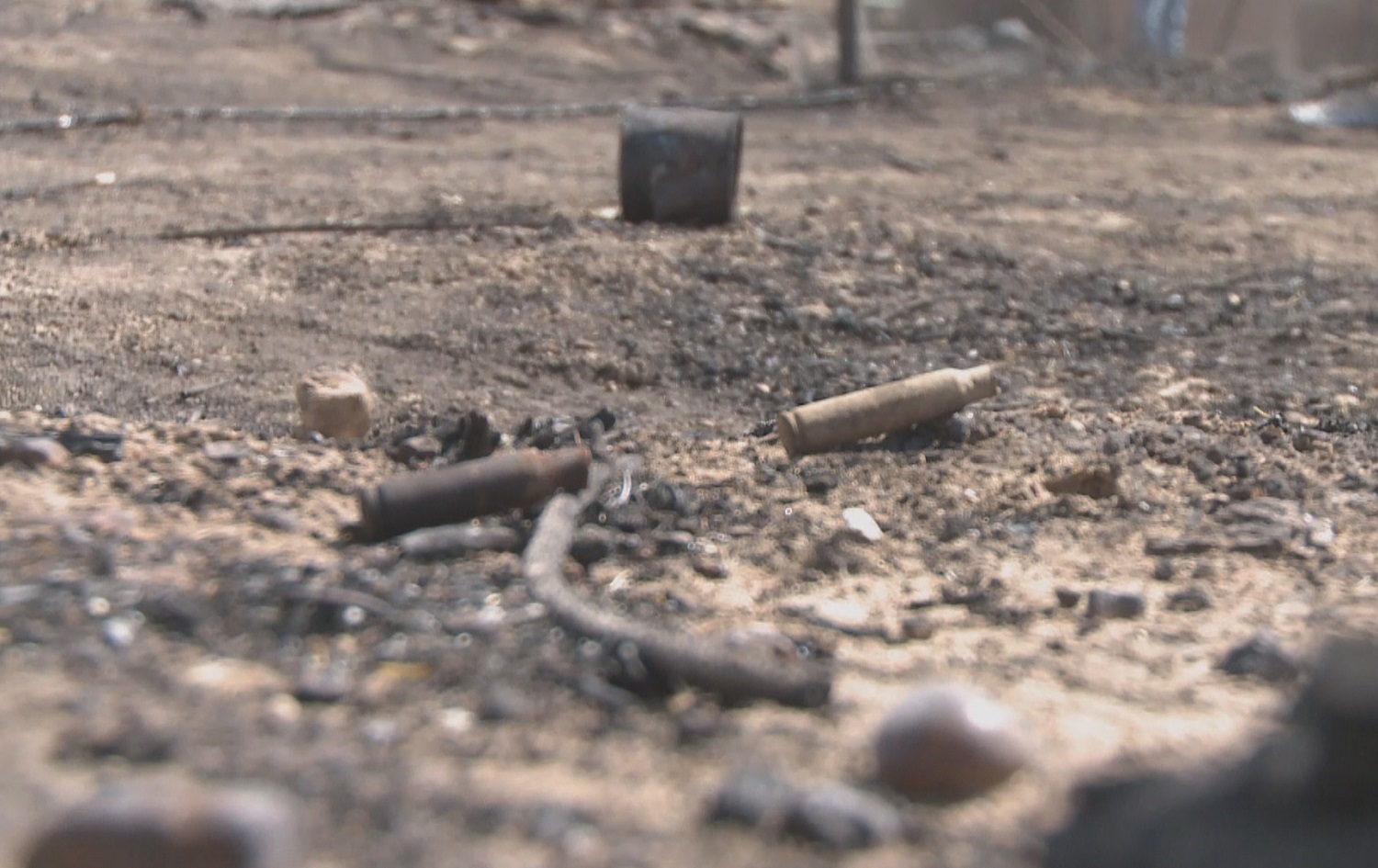 Spent cartridges are seen on the ground where family members discovered charred remains in the yard of their family home in Gir Ozer. Photo: Rudaw